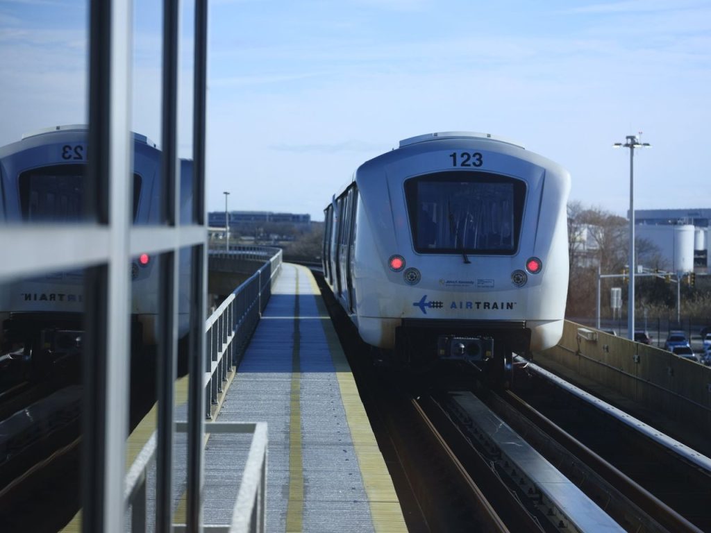 Trem de conexão aeroportuária chegando a uma estação elevada, em Nova York.